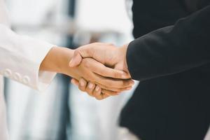 Success and Happiness Team Concept, Businessman and Businesswoman handshake finishing up a meeting photo