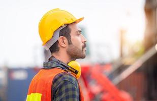 Engineer man in hardhat and safety vest control loading containers box from cargo, Logistic concept photo