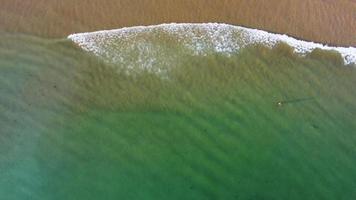 erstaunliche malerische Drohnenluftaufnahme des Strandes und des Ozeans mit ruhigen Wellen während eines Sonnenuntergangs mit lebendigen Farben. Algarve, Portugal. klares Wasser. Feiertage und Ferien. Hintergrund. Strand mit Felsen. video