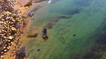 Amazing scenic drone aerial view of the beach and ocean with calm waves during a sunset with vibrant colors. Algarve, Portugal. Clear waters. Holidays and Vacations. Background. Beach with rocks. video