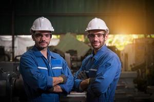 ingeniería industrial con control uniforme de seguridad que opera la máquina rectificadora de torno que trabaja en la fábrica de la industria. foto