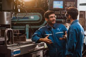 ingeniería industrial con control uniforme de seguridad que opera la máquina rectificadora de torno que trabaja en la fábrica de la industria. foto