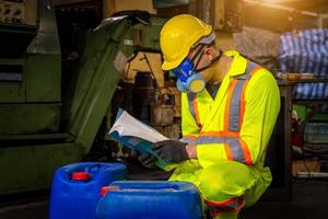 la industria del ingeniero con uniforme de seguridad, guantes negros, máscara de gas se siente sofocada cuando se revisa el tanque químico en el trabajo de la fábrica de la industria. foto