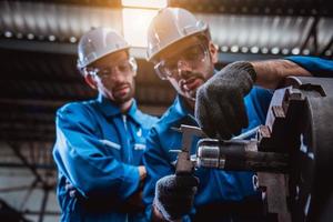 Industry engineering wearing safety uniform control operating computer controlled lathe grinding machine working in industry factory. photo