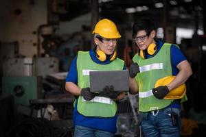 Industry engineering wearing safety uniform control operating computer controlled lathe grinding machine working in industry factory. photo