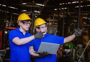 Industry engineering wearing safety uniform control operating computer controlled lathe grinding machine working in industry factory. photo
