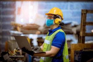 ingeniero bajo inspección y verificación del proceso de producción en la estación de fábrica con destornillador usando una máscara de seguridad para proteger contra la contaminación y el virus en la fábrica. foto