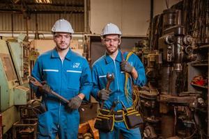 ingeniería industrial con control uniforme de seguridad que opera la máquina rectificadora de torno controlada por computadora que trabaja en la fábrica de la industria. foto