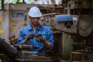 Industry engineering wearing safety uniform control operating computer controlled lathe grinding machine working in industry factory. photo