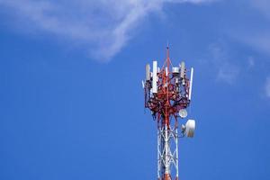 torre de telecomunicaciones sobre cielo azul brillante y fondo de nubes foto