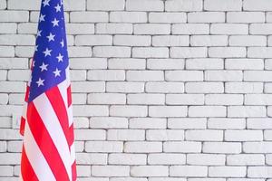 primer plano de la bandera americana contra el fondo de la pared de ladrillo blanco foto