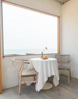 beautiful and empty minimal table and chair on side window photo