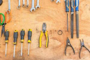 alicates y herramientas manuales en la pared de madera foto