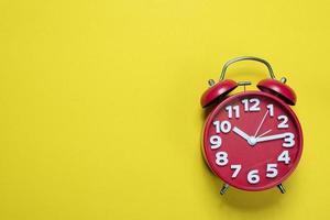 Red alarm clock images placed on a yellow background, time concept with copy space photo