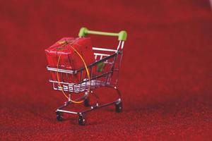 fondo rojo y carrito de compras concepto de compras y comercio foto