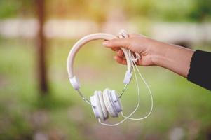 Hand and white headphones, devices for listening to music on a daily basis Music and music concepts photo