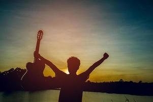 Silhouette of a guitarist in the shadows at sunset light, silhouette concept. photo