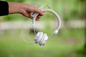 Hand and white headphones, devices for listening to music on a daily basis Music and music concepts photo