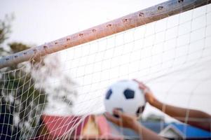 la imagen recortada de deportistas que atrapan la pelota y el campo de fútbol. concepto de imagen deportiva. foto