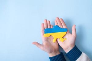 Ukrainian plasticine map of yellow-blue color of the national flag of Ukraine in a childs hands, top view photo