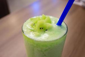 smoothie with fresh green kiwi fruits, wheat grass and herbs photo