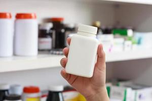 hand hold medicine bottle in the pharmacy photo