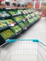 comprar algunas frutas y verduras en el supermercado con carrito de compras foto