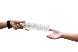 isolated two hands of human sending and receiving the empty plastic drinking water bottle with clipping paths. concept for helping to reduce using plastic bottles to save the environment. photo