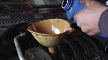 Automechaniker gießt Öl in einen Motor. video