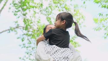 la pequeña hija feliz abraza y besa a su madre en el parque. concepto de relación familiar video