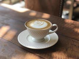 Hot coffee cup on wooden table photo
