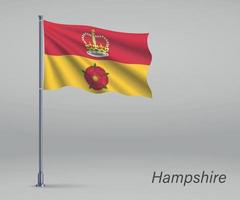 Waving flag of Hampshire - county of England on flagpole. vector