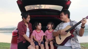 lycklig familj njuter av roadtrip på sommarlovet. familjen åker på vägen i sin favoritbil. semester och resor familj koncept. video