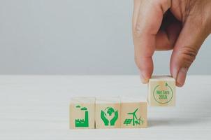 cubos de madera con cero neto y fondo de símbolo de icono de fábrica verde neutro en carbono y espacio de copia. foto