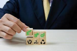 Hand put wooden cubes with ESG Environmental Social Governance symbol on table copy space.Business concepts.