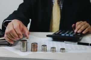 Male hands holding coins and paper documents calculator.Business economic finance tax and investment concepts. photo