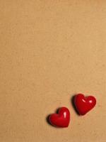 two red ceramic hearts on love letter paper background photo