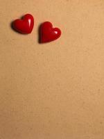 two red ceramic hearts on love letter paper background photo