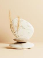 3d minimal pebble display podiums with dried grass on beige background. 3d rendering of abstract presentation for product advertising. 3d minimal illustration. photo