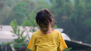 Cute little girl having fun catching rain drops. Kids play in summer rain. Child playing outdoor on rainy day. video
