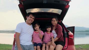 gelukkige familie genieten van road trip op zomervakantie. de familie reist op de weg in hun favoriete auto. vakantie en reizen familie concept. video