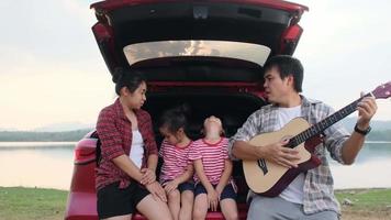 familia feliz disfrutando de un viaje por carretera en vacaciones de verano. la familia viaja por la carretera en su coche favorito. concepto familiar de vacaciones y viajes. video