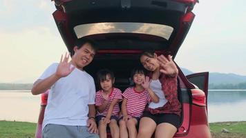 lycklig familj njuter av roadtrip på sommarlovet. familjen åker på vägen i sin favoritbil. semester och resor familj koncept. video