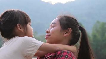 la pequeña hija feliz abraza y besa a su madre en el parque. concepto de relación familiar video
