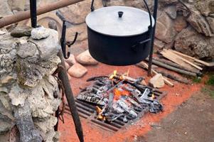 burning firewood on a grate with a pot photo