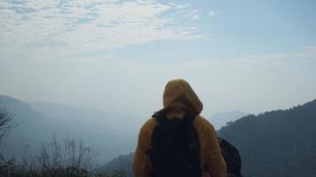 Successful woman hiker open arms on top of a mountain. Happy woman standing raised hands on the background of the sunrise during the mountains. video