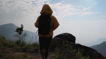 Successful woman hiker open arms on top of a mountain. Happy woman standing raised hands on the background of the sunrise during the mountains. video