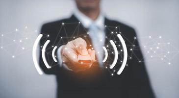 Using the remote to connect electrical appliances concept, Businessman holding remote connecting channel and presses the button on the remote control. Remote control in hand closeup. photo