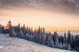 Magic sunset in the snowy mountains. Vintage effect photo