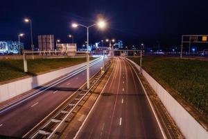 la carretera asfaltada está iluminada por la noche. foto